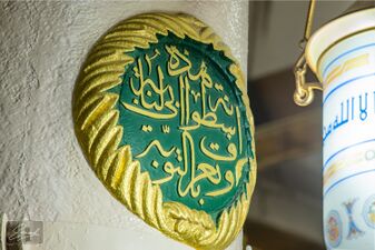 نوشته‌ای که بالای ستون توبه نقش شده است: «هذه اسطوانة ابی‌لبابة و تعرف بالتوبة»[یادداشت ۲]